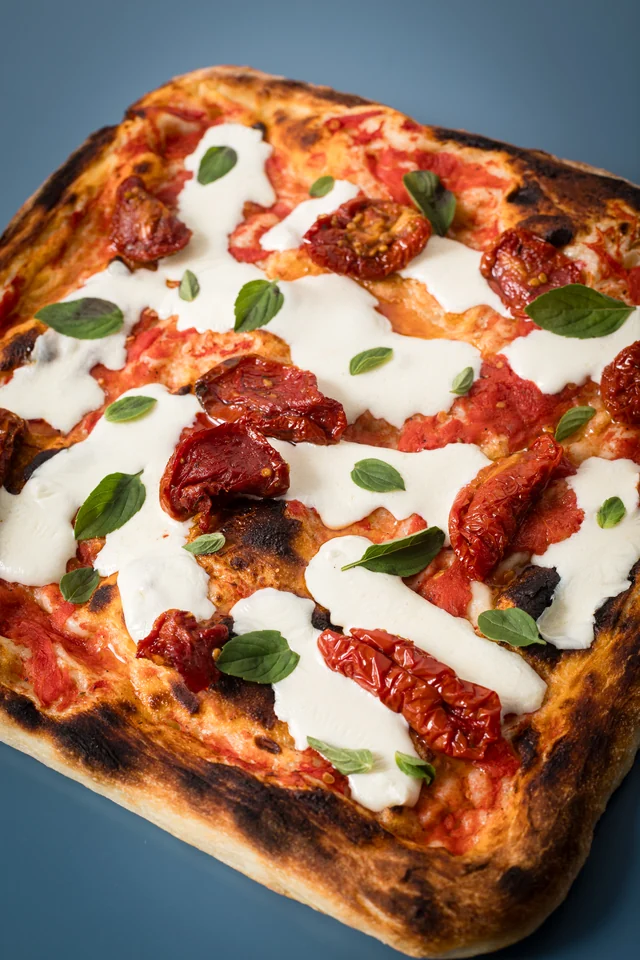 Mozzarella de búfala finalizada em casa com tomate seco e manjericão