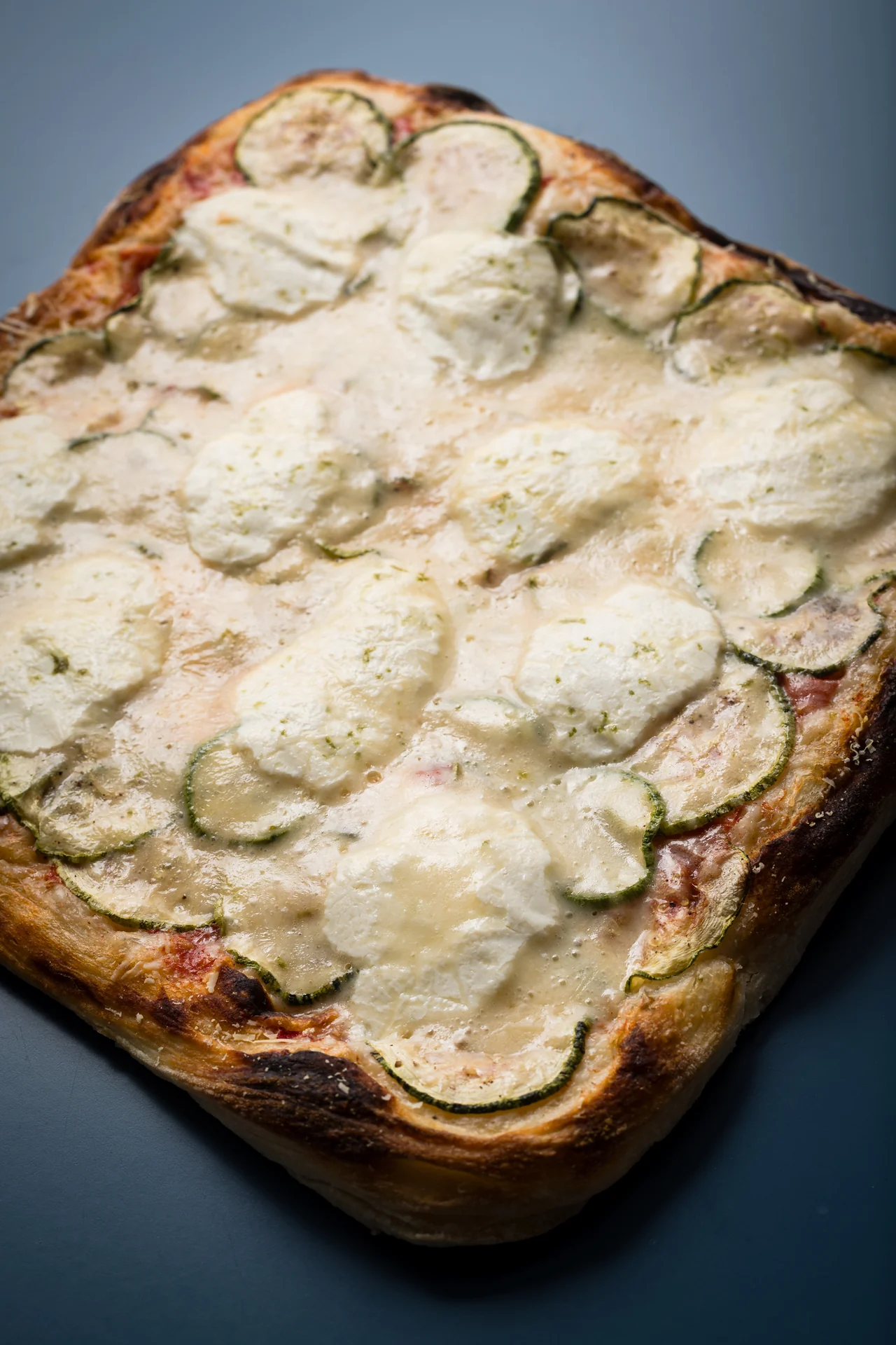 Detalhe da pizza Abobrinha da Oficina Lievito, com borda dourada